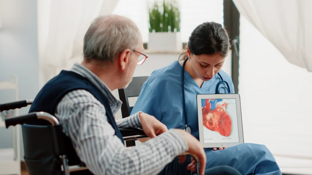 A clinician showing a patient a heart model on a tablet